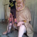 trabajadora pintando escultura