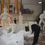 trabajador con varias esculturas alrededor